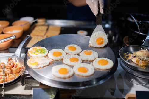 In the kitchen there was a chef cooking food and in a pan there were many fondants of fried starch that looked delicious and delicious. Including a menu of crispy bread topped with cheese. photo