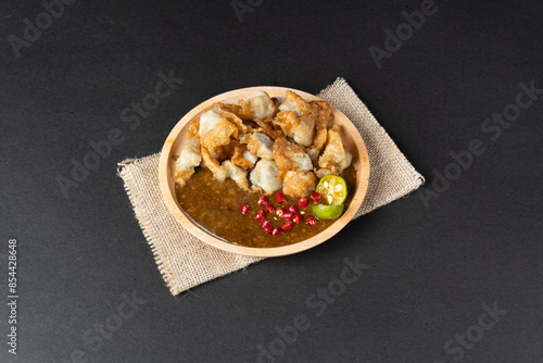 Delicious batagor or meatballs tofu is one of the popular indonesian traditional foods. Made from fish, tofu and peanut sauce. on wooden plate photo