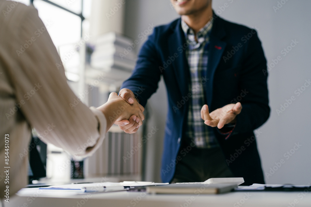 Business Professionals Shaking Hands in Modern Office Setting, Sealing a Deal or Agreement, Collaborative Work Environment Business Professionals Shaking Hands in Modern Office Setting, Sealing a Deal or Agreement, Collaborative Work Environment