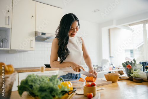 Young Woman Preparing Fresh Vegetables in a Bright Modern Kitchen with Natural Light