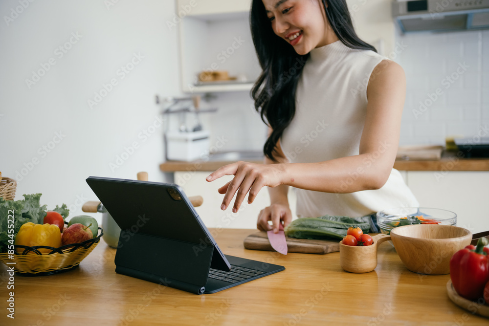 Woman Cooking in Modern Kitchen Using Tablet for Recipe Guidance, Surrounded by Fresh Vegetables and Ingredients Woman Cooking in Modern Kitchen Using Tablet for Recipe Guidance, Surrounded by Fresh Vegetables and Ingredients