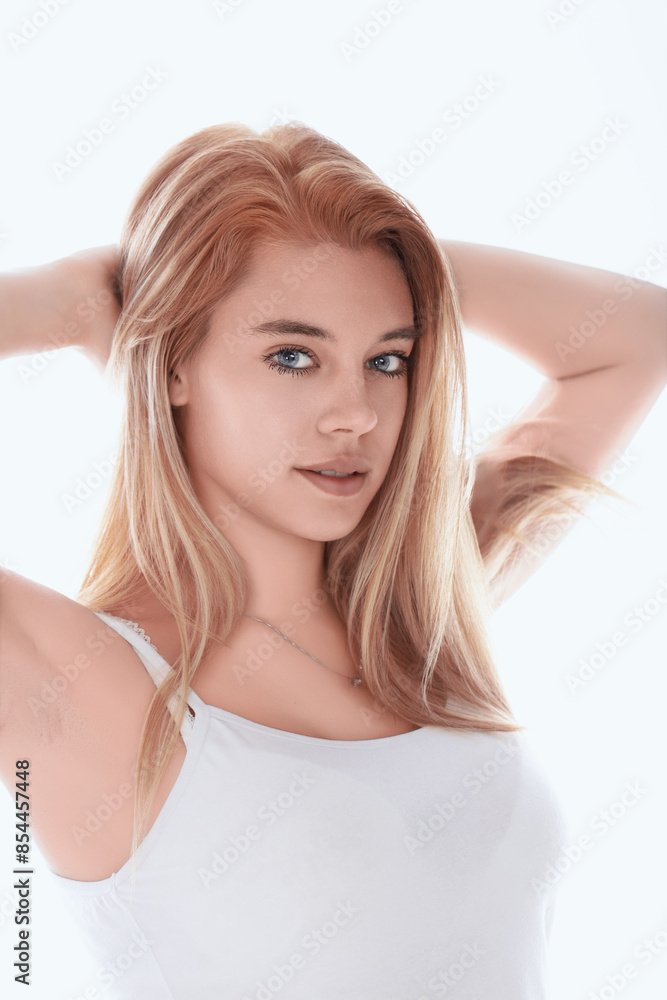 Young woman with long blonde hair is holding her head with her h Young woman with long blonde hair is holding her head with her h