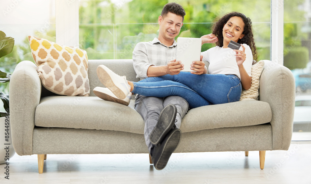 Obraz premium Tablet, credit card and couple on sofa in living room for mortgage, debt or property investment payment. Happy, relax and people with digital technology for internet bank with online shopping at home