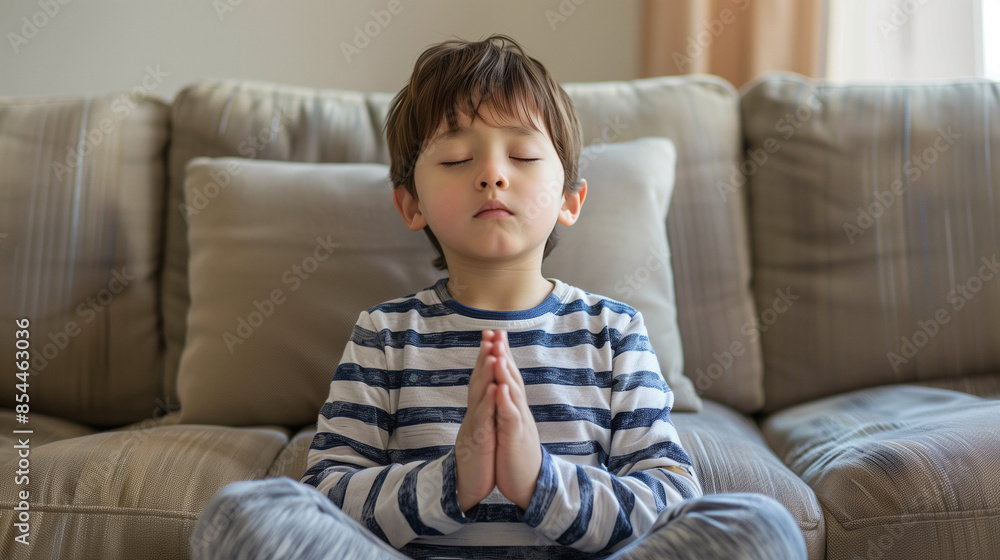 家のソファーで手を合わせて目を瞑って瞑想(ヨガ)をしている子ども 男の子 6歳 7歳 アジア人 家のソファーで手を合わせて目を瞑って瞑想(ヨガ)をしている子ども 男の子 6歳 7歳 アジア人