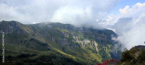 Mountain peak enveloped in clouds, creating majestic atmosphere for adventure in serene wilderness