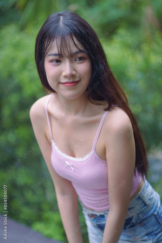 A pretty young Asian woman in a pink color tank top and fashionable short denim jean skirts for casual days. Beautiful portrait fashion of modern cute teenagers. A pretty young Asian woman in a pink color tank top and fashionable short denim jean skirts for casual days. Beautiful portrait fashion of modern cute teenagers.