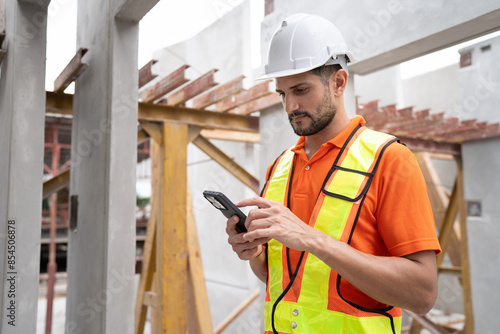 Portrait Hispanic latin engineer man use smartphone checking precast cement at precast cement outdoor factory 