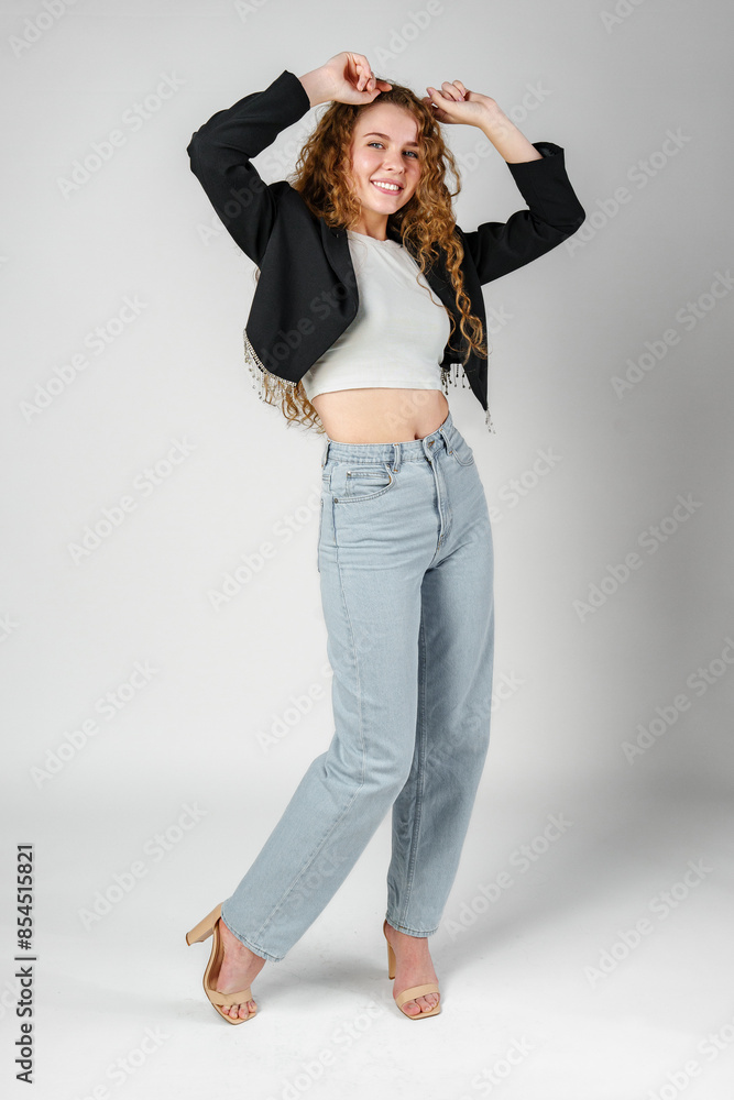 Joyful Young Woman Dancing Alone in Light-Colored Casual Attire Against a Grey Background Joyful Young Woman Dancing Alone in Light-Colored Casual Attire Against a Grey Background