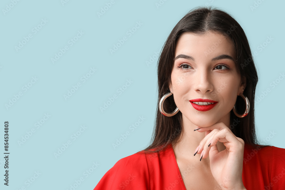 Beautiful young woman with red lipstick on blue background Beautiful young woman with red lipstick on blue background