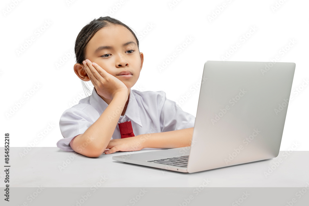 Portrait of an Asian elementary school student girl with a laptop tired of learning on the table Portrait of an Asian elementary school student girl with a laptop tired of learning on the table