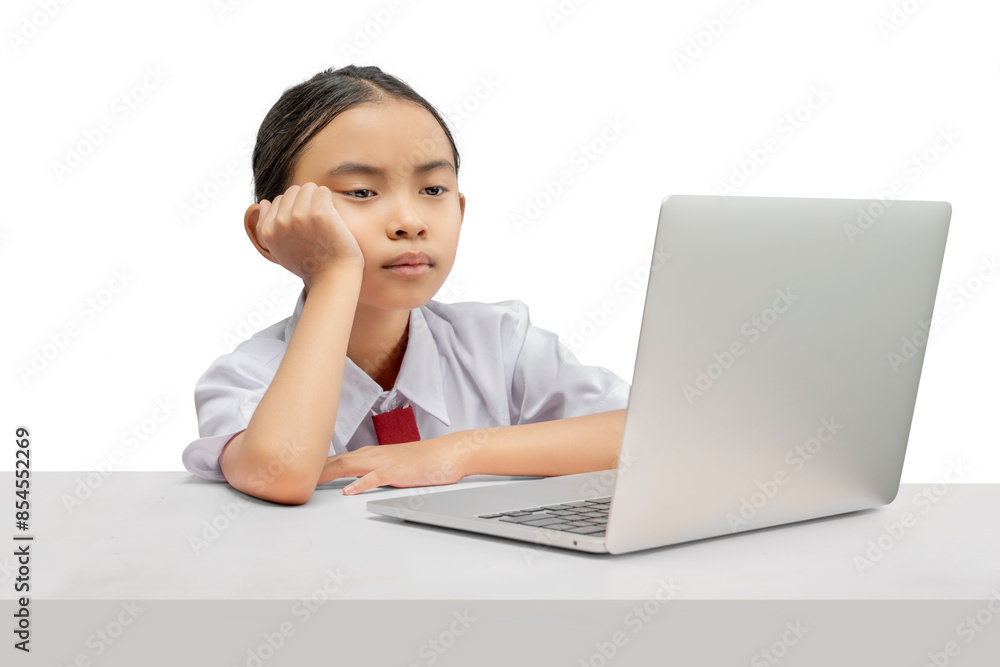 Portrait of an Asian elementary school student girl with a laptop tired of learning on the table Portrait of an Asian elementary school student girl with a laptop tired of learning on the table
