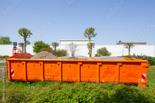 Container, orange Absetzmulde für Bauschutt auf einer Wiese stehend, Deutschland photo