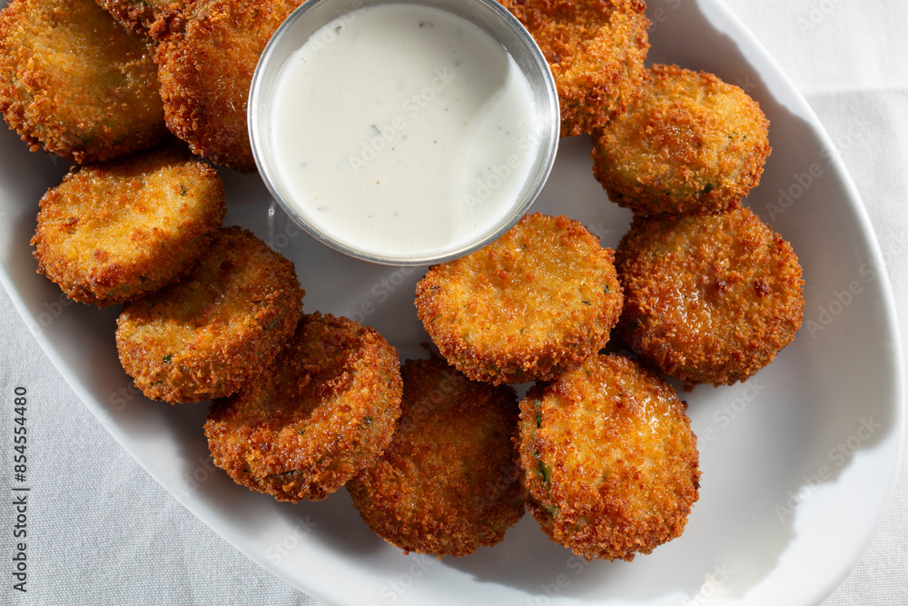 A top down view of a plate of deep fried zucchini. A top down view of a plate of deep fried zucchini.
