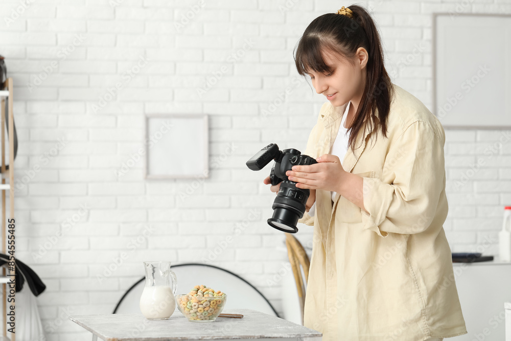 Female food photographer taking picture of cereal rings with milk in studio Female food photographer taking picture of cereal rings with milk in studio