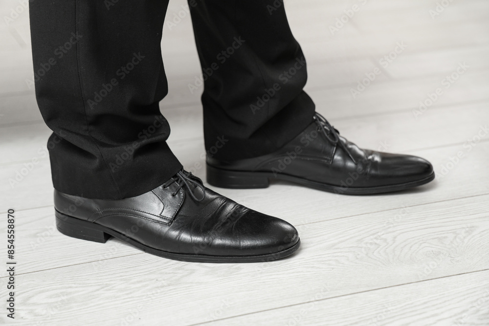 Male legs in stylish leather shoes indoors, closeup Male legs in stylish leather shoes indoors, closeup