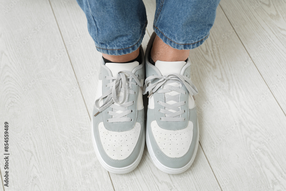 Male legs in stylish sneakers indoors, closeup Male legs in stylish sneakers indoors, closeup