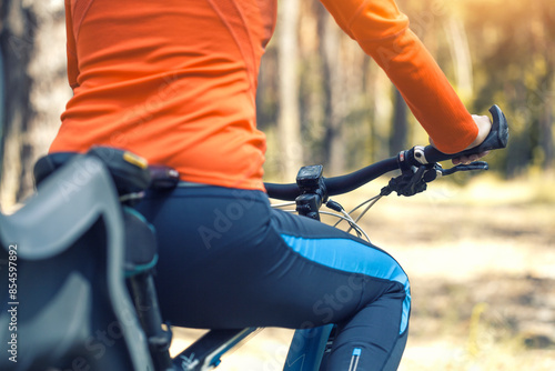 woman cyclist rides in the forest on a mountain bike.