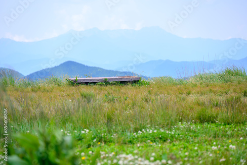 夏の高原に置かれた椅子と美しい山々の風景