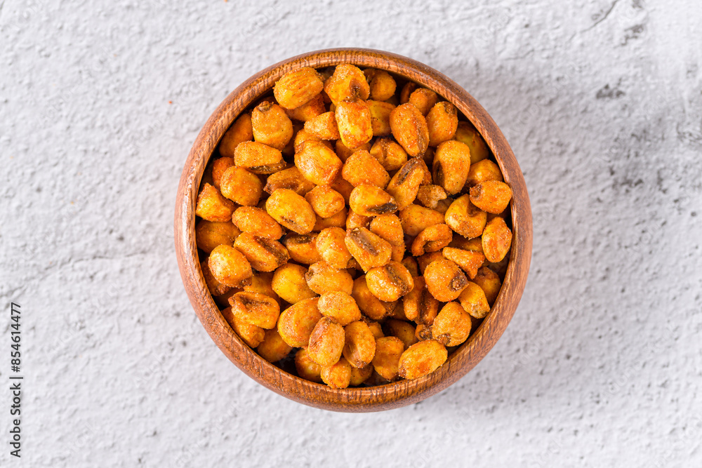 Roasted corn nuts with sauce in wooden bowl on white stone table Roasted corn nuts with sauce in wooden bowl on white stone table