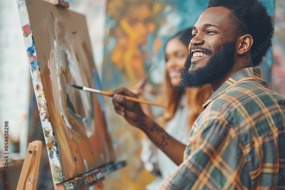 In a workshop, a painter or African person with brush, class and talent for design or watercolor painting on canvas or easel for therapy, drawing, or studio work. In a workshop, a painter or African person with brush, class and talent for design or watercolor painting on canvas or easel for therapy, drawing, or studio work.