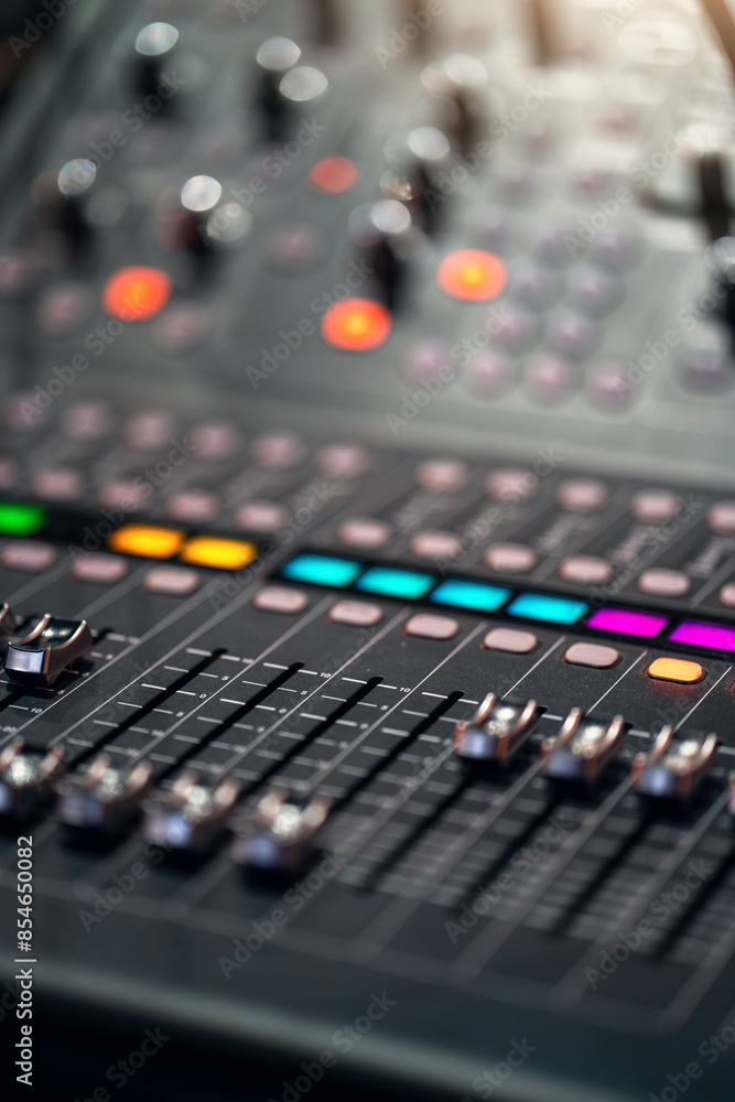 Professional audio mixing console with colorful illuminated buttons and sliders, used in music production and live performances. Professional audio mixing console with colorful illuminated buttons and sliders, used in music production and live performances.