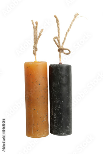 Two pillar candles, one yellow and one black, with twine wicks.  They are both unlit.  The candles are standing upright. isolated on a white background. photo