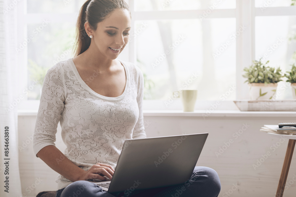 Young woman networking with her laptop at home Young woman networking with her laptop at home