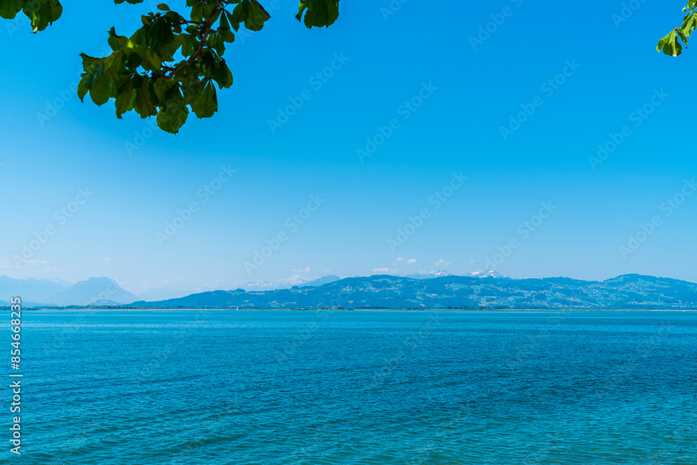 Germany, beautiful view to white snow covered mountain summits of alps, saentis and switzerland from lindau in summer with blue sky panorama