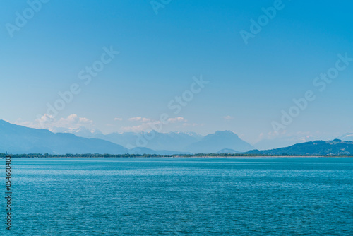 Obraz na płótnie Germany, enchanting view to white snow covered mountain peaks of alps from lindau in summer with blue sky panorama behind water of bodensee lake w salonie