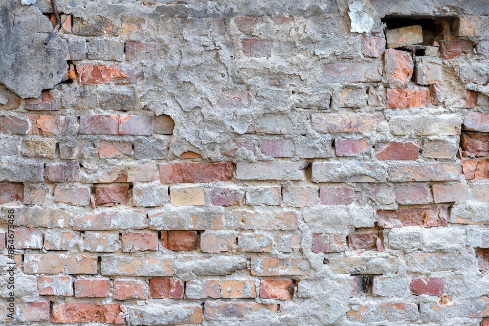 Fototapeta premium Destroyed plaster on an old red brick wall. Grunge background.
