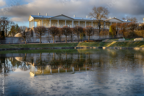 Cameron's Gallery of the 18th century illuminated by the morning sun and reflected in the water with the first pieces of ice after the night frosts (Tsarskoye Selo, St. Petersburg) photo