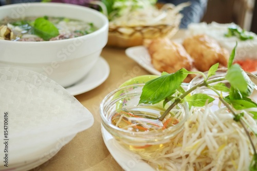 A plate of sugarcane prawns, fresh bean sprouts, nuoc cham sauce and basket of fresh herbs for rice paper rolls at Phu Quoc, a Vietnamese Chinese restaurant in Cabramatta - Sydney, NSW, Australia  photo