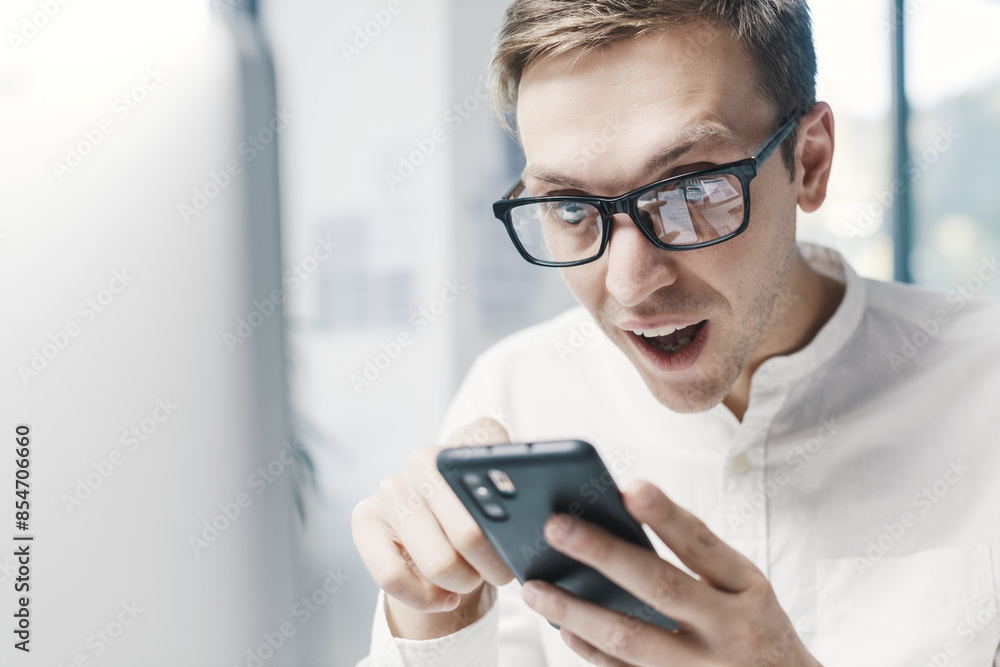 Shocked businessman connecting with his smartphone Shocked businessman connecting with his smartphone