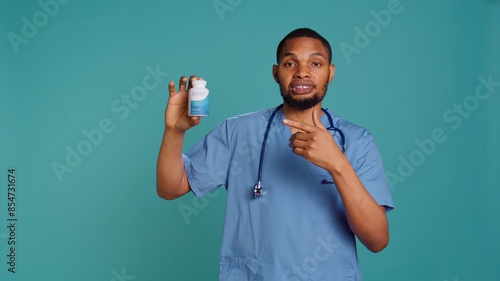 Photos Portrait of hospital staff member holding sleep deprivation medicine for insomniacs, studio background