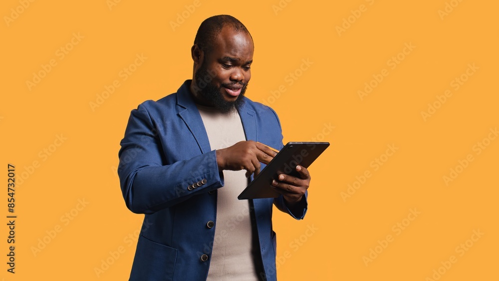 Irked man upset after lacking money while trying to buy stuff online. Grumpy person looking at debit card after getting transaction rejected on tablet, doing facepalm, studio background, camera B Irked man upset after lacking money while trying to buy stuff online. Grumpy person looking at debit card after getting transaction rejected on tablet, doing facepalm, studio background, camera B