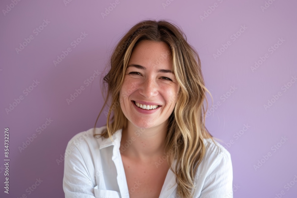 Portrait of a content woman in her 30s smiling at the camera on soft purple background Portrait of a content woman in her 30s smiling at the camera on soft purple background