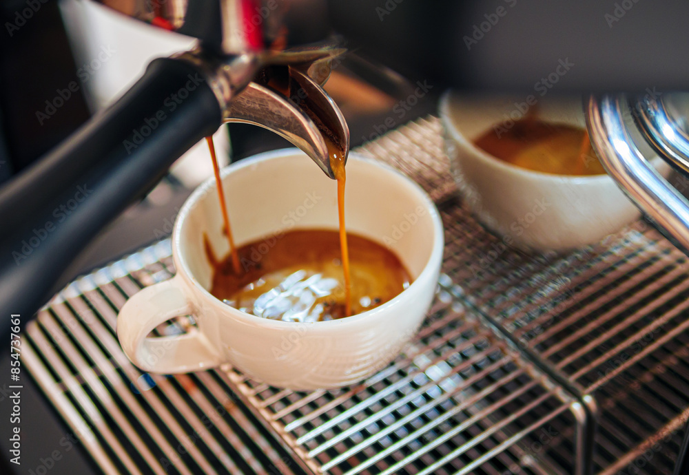 Close-up of espresso pouring from the coffee machine into a coffee cup. Professional coffee brewing Close-up of espresso pouring from the coffee machine into a coffee cup. Professional coffee brewing