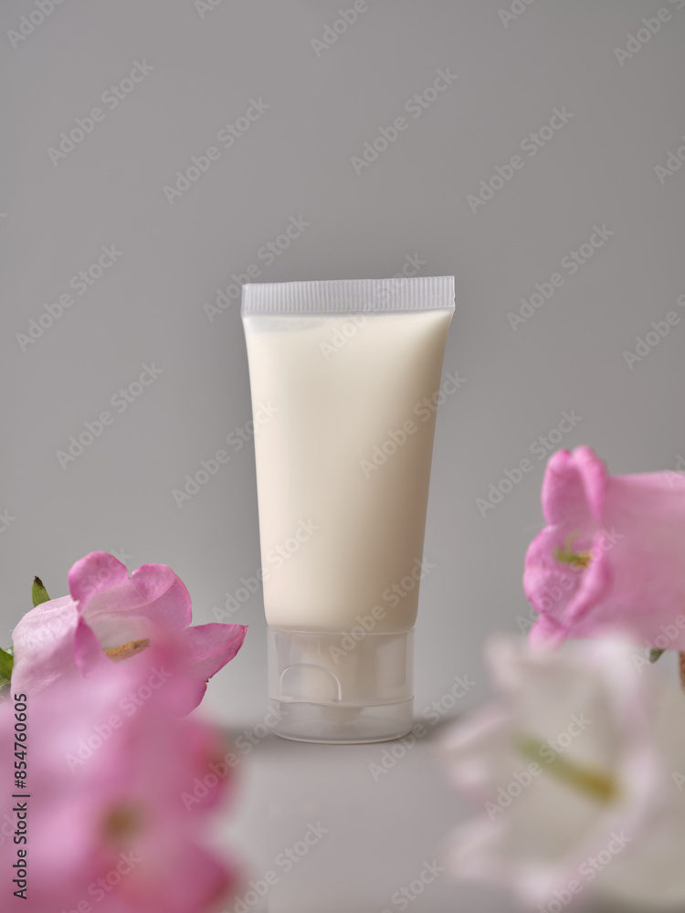 Skincare products on neutral background. Mockup bottles and flowers with copy space. Face cream and body lotion Skincare products on neutral background. Mockup bottles and flowers with copy space. Face cream and body lotion