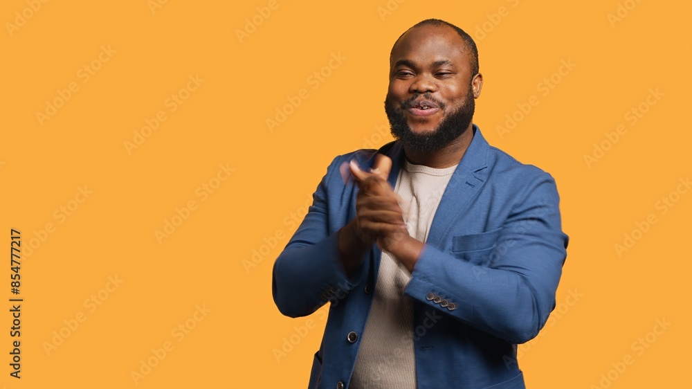Approving joyful african american man happily clapping hands, ecstatic about accomplishments. Excited BIPOC person cheering, applauding, isolated over studio background, camera A Approving joyful african american man happily clapping hands, ecstatic about accomplishments. Excited BIPOC person cheering, applauding, isolated over studio background, camera A