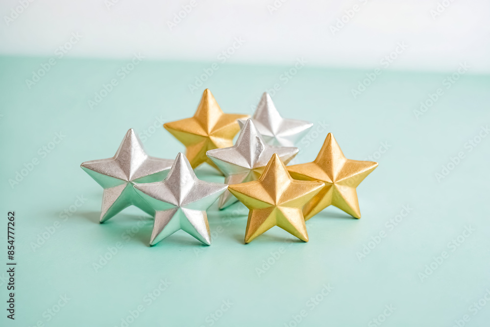 Obraz premium Gold and Silver Stars on a Mint Green Background