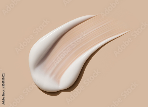 creamy smear of white cosmetic texture close up on beige background skin care concept