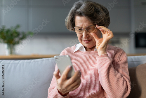 Photos Confused senior woman in eyeglasses squinting eyes, having problems with vision,