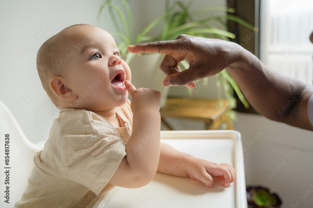 African American adult's hand touching his baby's face African American adult's hand touching his baby's face