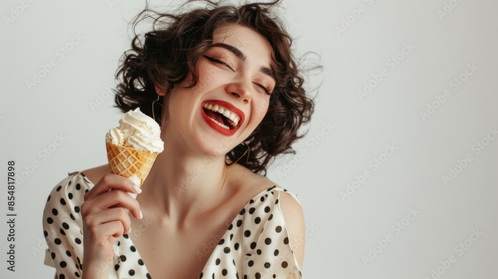 Model posing with Ice Cream: Brunette woman in a yellow polka dot dress, holding her ice cream cone playfully to her lips, with a clean, isolated light white background. Model posing with Ice Cream: Brunette woman in a yellow polka dot dress, holding her ice cream cone playfully to her lips, with a clean, isolated light white background.