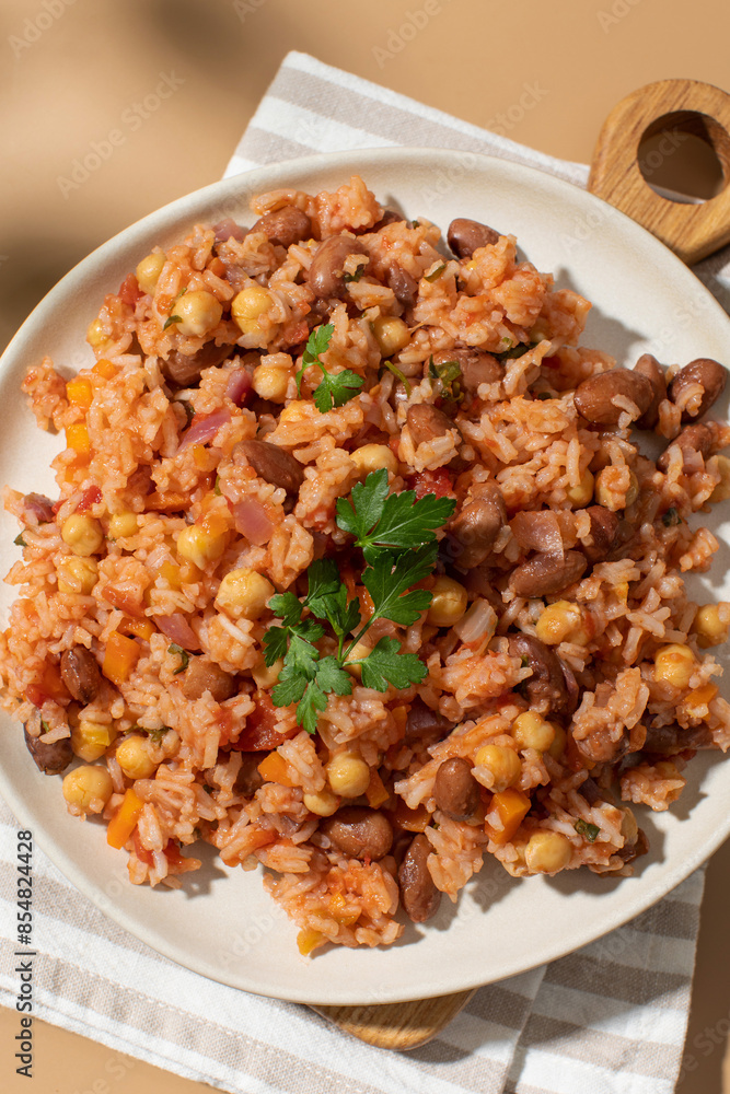 Jambalaya with rice chickpeas and kidney beans on beige table Jambalaya with rice chickpeas and kidney beans on beige table