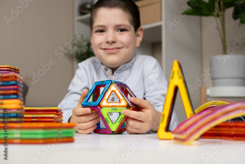 A child plays with a magnetic construction set. Interesting educational toys.