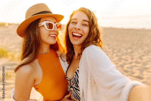 Cheerful women making selfie while having fun on the beach. Friends together. Travel, blogging, weekend, relax and lifestyle concept. © maxbelchenko