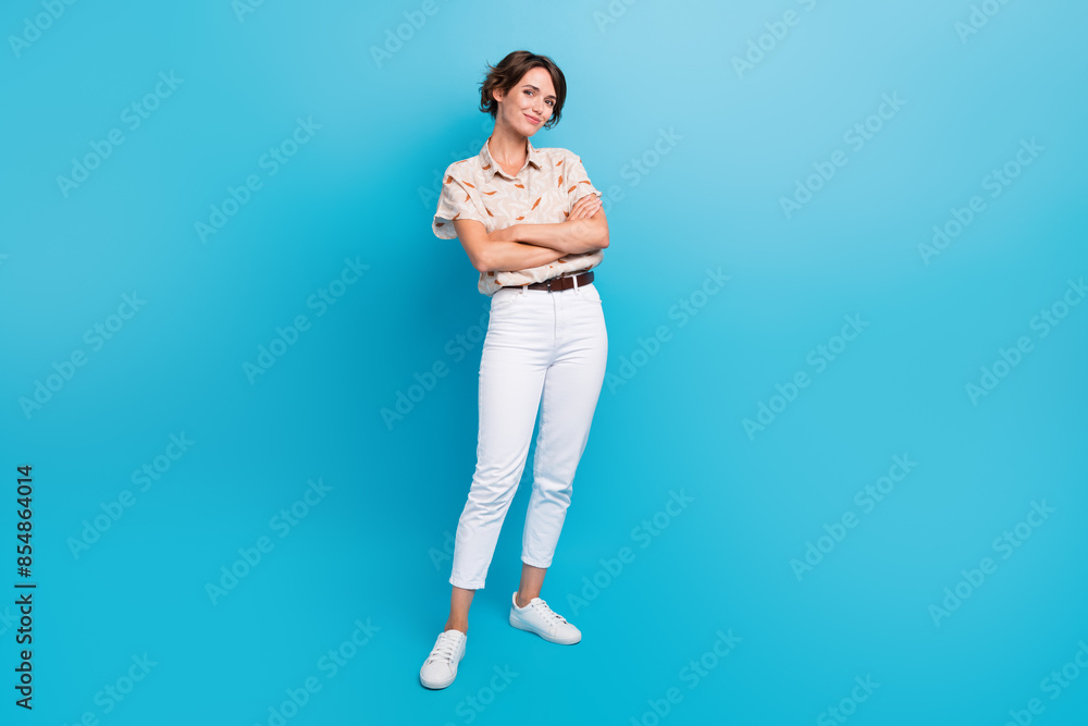 Full size photo of stunning positive girl crossed arms posing empty space isolated on blue color background Full size photo of stunning positive girl crossed arms posing empty space isolated on blue color background
