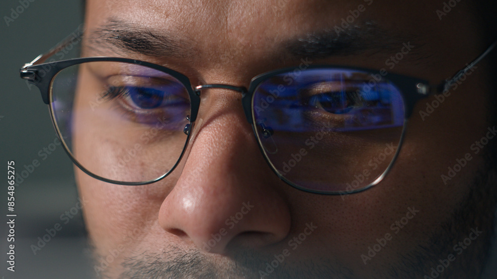 Close up male eyes in eyeglasses laptop monitor light programming codding cyberspace man businessman wear computer glasses reducing eye strain blurred vision looking at pc screen computer reflection Close up male eyes in eyeglasses laptop monitor light programming codding cyberspace man businessman wear computer glasses reducing eye strain blurred vision looking at pc screen computer reflection