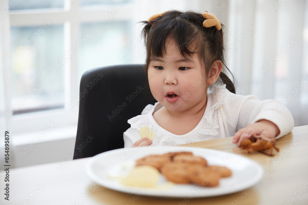 portrait child girl enjoy eating potato chips in the kitchen portrait child girl enjoy eating potato chips in the kitchen